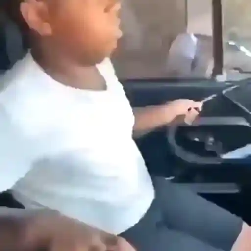 Figurinha: Criança finge dirigir carro