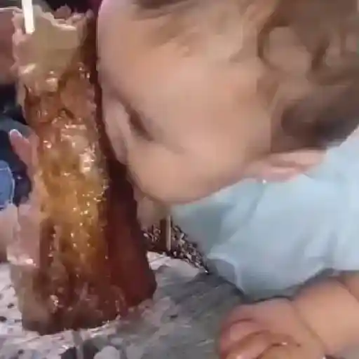 Figurinha: Bebê comendo doce gigante