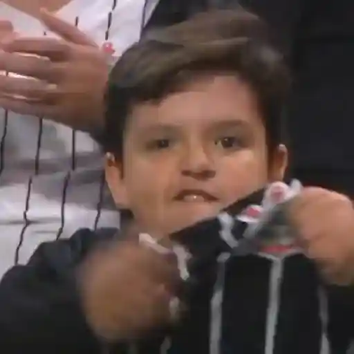 Figurinha: Menino comemora gol e fecha ouvidos