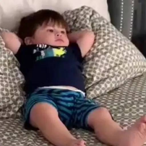 Figurinha: Bebê relaxado na cama