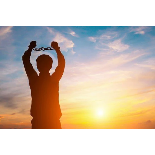 Figurinha: Homem quebra correntes ao pôr do sol